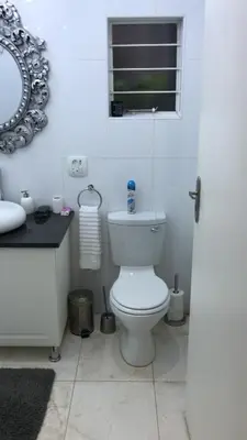 a bathroom with a toilet and a sink and a mirror at 513 on Mulberry in Pretoria