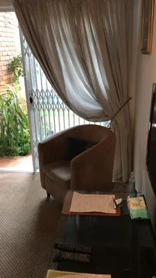 a living room with a couch and a table and a window at 513 on Mulberry in Pretoria