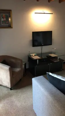 a living room with a tv and a couch and a chair at 513 on Mulberry in Pretoria