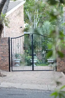 a black iron gate in front of a house at 513 on Mulberry in Pretoria