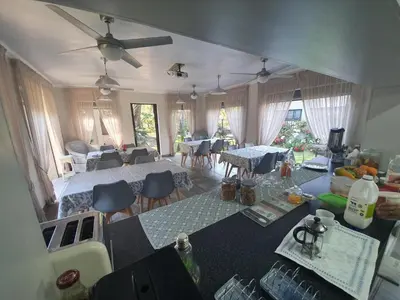 an aerial view of a living room with tables and chairs at Three Olives Guesthouse in Centurion
