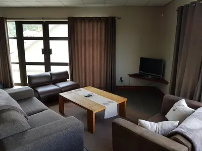 a living room with two couches and a coffee table at Stay@67 Apartments - Dullstroom in Dullstroom