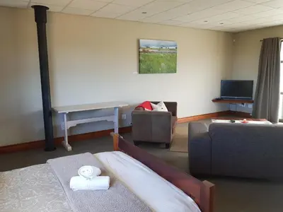 a living room with a bed and a couch and a piano at Stay@67 Apartments - Dullstroom in Dullstroom