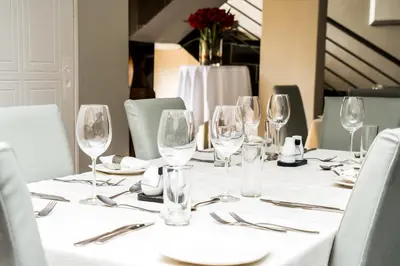 a table with wine glasses and silverware on it at Ruby Stone Boutique Hotel in Polokwane