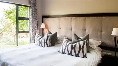 a bedroom with a large white bed with pillows at The Blades in Pretoria