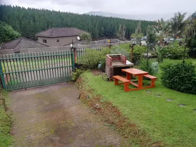 a picnic table in a yard next to a fence at Yorkdale Cabin in Sabie