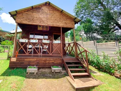 a large wooden cabin with stairs and a porch at Yorkdale Cabin in Sabie