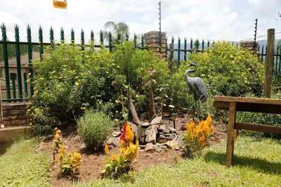 a garden with a statue of a bird in a yard at Yorkdale Cabin in Sabie