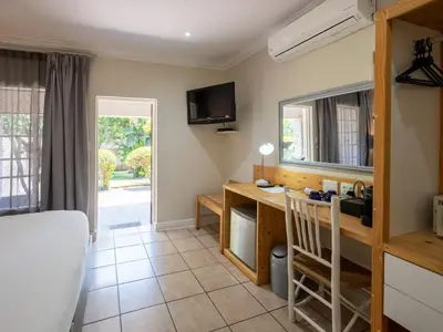 a room with a desk and a tv on the wall at ANEW Resort White River Mbombela in White River
