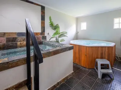 a bathroom with a tub and a stool in it at ANEW Resort White River Mbombela in White River