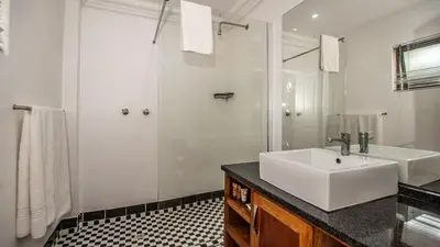 a white bathroom with a sink and a shower at ANEW Resort White River Mbombela in White River