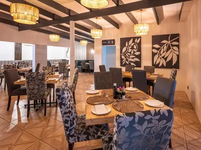 a dining room with tables and chairs and chandeliers at ANEW Resort White River Mbombela in White River