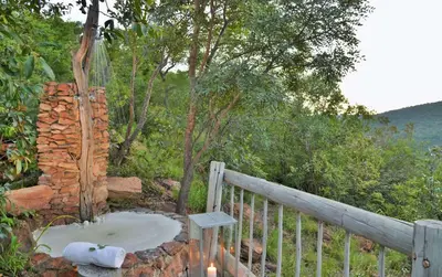 an outdoor bath room with a fence and trees at Clifftop Exclusive Safari Hideaway in Welgevonden Game Reserve
