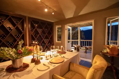 a dining room with a table with wine bottles at Clifftop Exclusive Safari Hideaway in Welgevonden Game Reserve