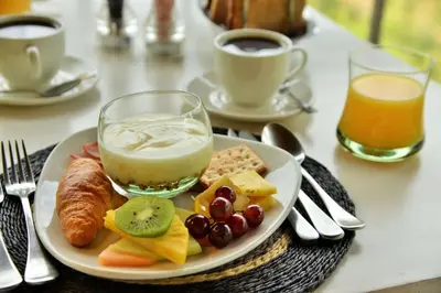 a plate of food on a table with coffee and juice at Clifftop Exclusive Safari Hideaway in Welgevonden Game Reserve