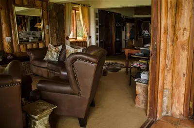 a living room with a leather couch and chairs at Hartbeespoortdam Lodge in Hartbeespoort