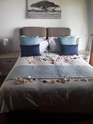 a bed with a bunch of flowers on it at Hartbeespoortdam Lodge in Hartbeespoort