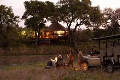 a group of people standing next to a jeep with a tent at Hamiltons Tented Camp in Mluwati Concession