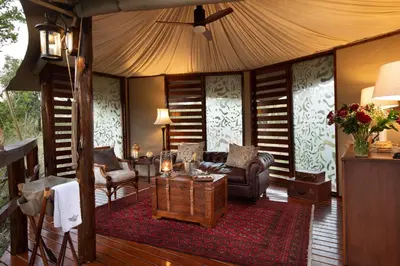 a living room with a couch and a table at Hamiltons Tented Camp in Mluwati Concession