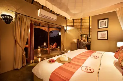 a bedroom with a bed with a hat on it at Hoyo Hoyo Safari Lodge in Mluwati Concession