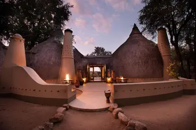 an entrance to a home with a building with grass roofs at Hoyo Hoyo Safari Lodge in Mluwati Concession