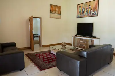 a living room with a couch and a television at Fumani Game Lodge in Modimolle