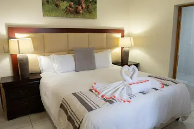a hotel room with a bed with a swan on it at Fumani Game Lodge in Modimolle