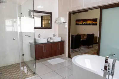 a bathroom with two sinks and a tub and a shower at Fumani Game Lodge in Modimolle