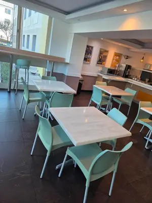 a cafeteria with tables and chairs and a counter at SUN1 MIDRAND in Midrand