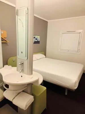 a bathroom with a bed and a sink and a mirror at SUN1 MIDRAND in Midrand