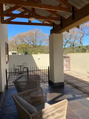 a patio with chairs and a table and a fence at Bergdale Cottages in Hazyview
