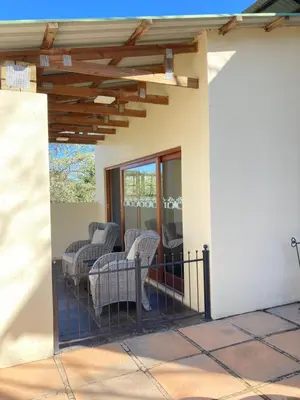 a patio with chairs and tables on a porch at Bergdale Cottages in Hazyview