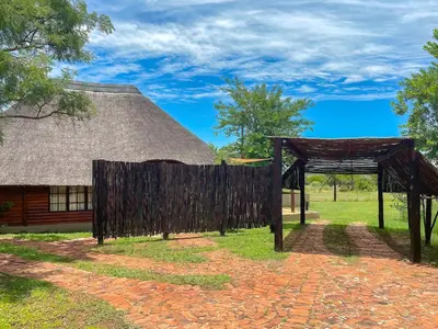 a pavilion in front of a building with a roof at iKhaya LamaDube Game Lodge in Klipdrift
