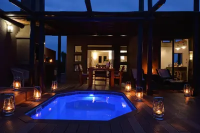 a swimming pool on a deck with candles and lights at iKhaya LamaDube Game Lodge in Klipdrift