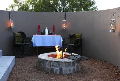 a table and a fire pit with a table and chairs at iKhaya LamaDube Game Lodge in Klipdrift