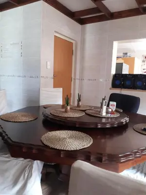 a wooden table with five chairs and a mirror at Paul & Mollie's Guest House in Brits