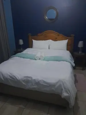 a bed with two towels on top of it at Paul & Mollie's Guest House in Brits