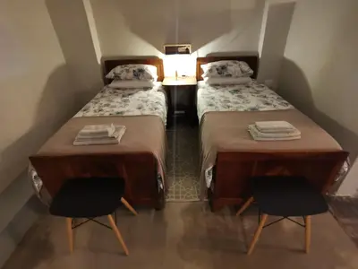 two beds in a small room with two chairs at MacNut Bed and Breakfast in Nelspruit