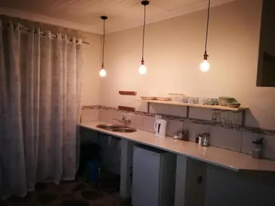 a kitchen with a counter with a sink and lights at MacNut Bed and Breakfast in Nelspruit