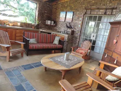 a living room with a couch and a table and chairs at MacNut Bed and Breakfast in Nelspruit