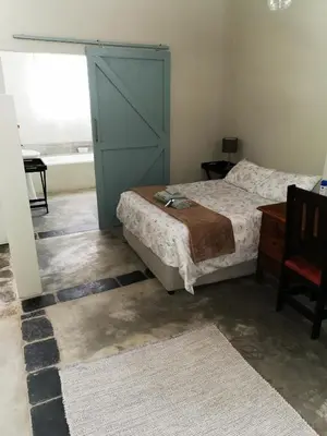 a bedroom with a bed and a blue door at MacNut Bed and Breakfast in Nelspruit
