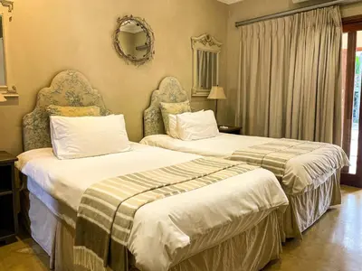 two beds sitting next to each other in a hotel room at Telestai Guest House in White River