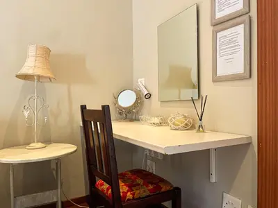a dressing table with a mirror and a chair at Telestai Guest House in White River