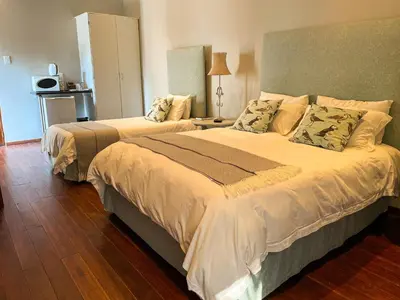 a bedroom with two beds and a table with a lamp at Telestai Guest House in White River