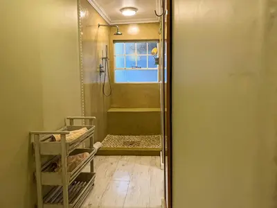 a shower with a glass door in a bathroom at Telestai Guest House in White River