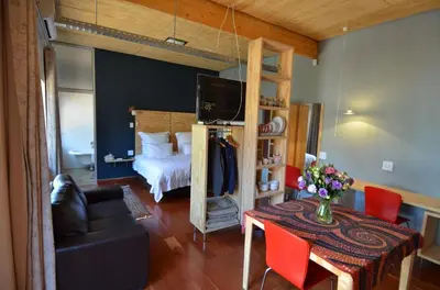 a bedroom with a bed and a table with a couch at Bed & Breakfast in Hatfield in Pretoria