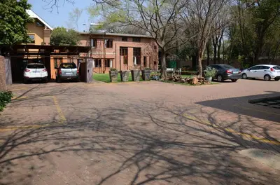 a parking lot with cars parked in front of a building at Bed & Breakfast in Hatfield in Pretoria