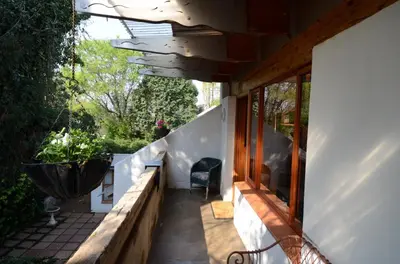 a porch of a house with a table and a chair at Bed & Breakfast in Hatfield in Pretoria