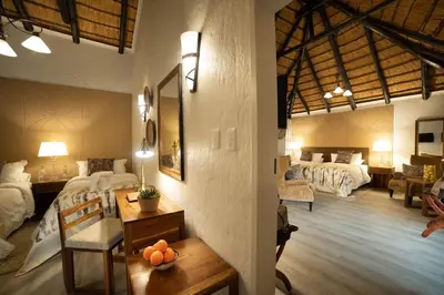 a room with two beds and a table with oranges on it at Mabula Game Lodge in Mabula