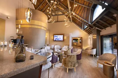 a restaurant with tables and chairs and a bar at Mabula Game Lodge in Mabula
